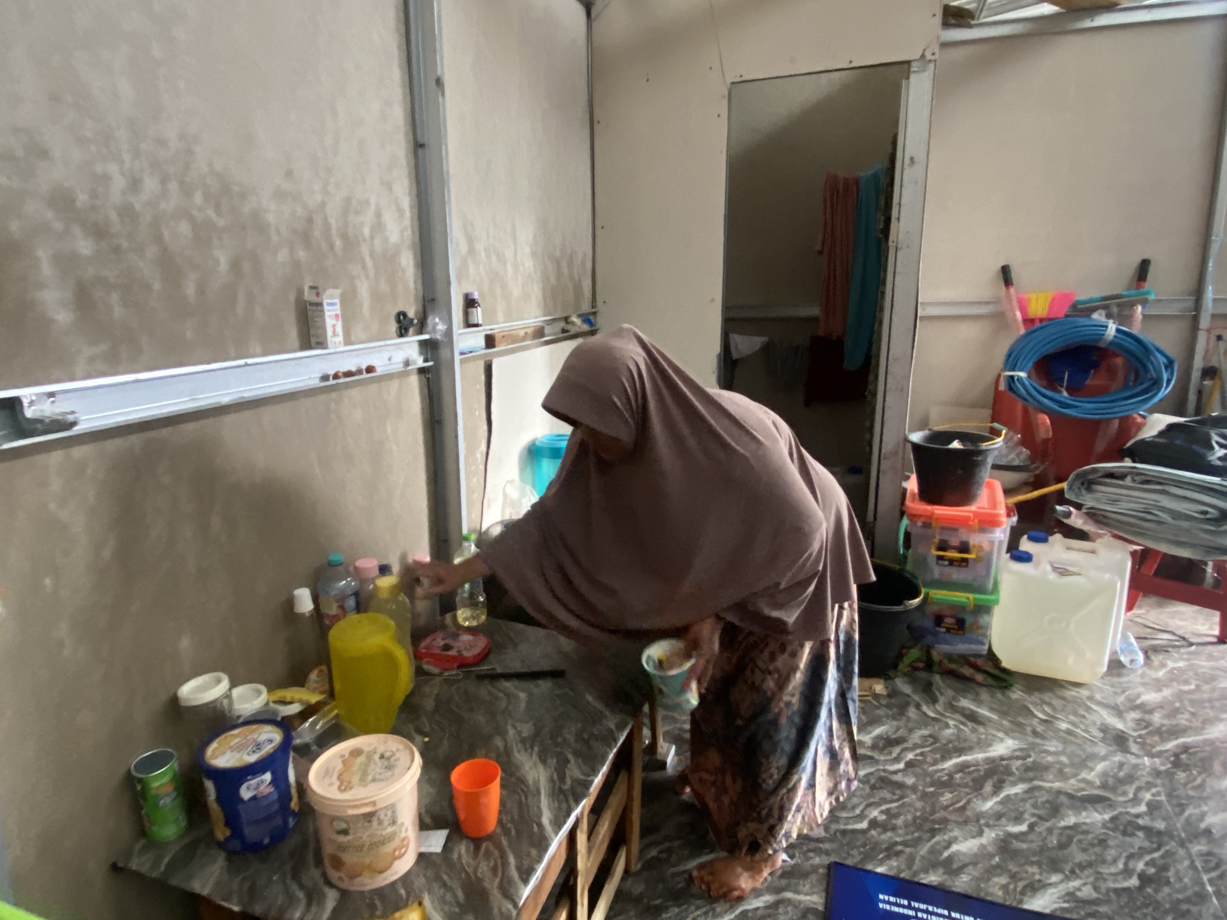 Ratmiati sedang menyeduh mi instan di hunian sementara di Desa Salareh Aia, Kabupaten Agam, Sumatra Barat, Selasa, 21/7/2026. Pascabanjir bandang, para pengungsi kesulitan bertahan hidup karena bantuan minim dan akses bekerja terbatas.